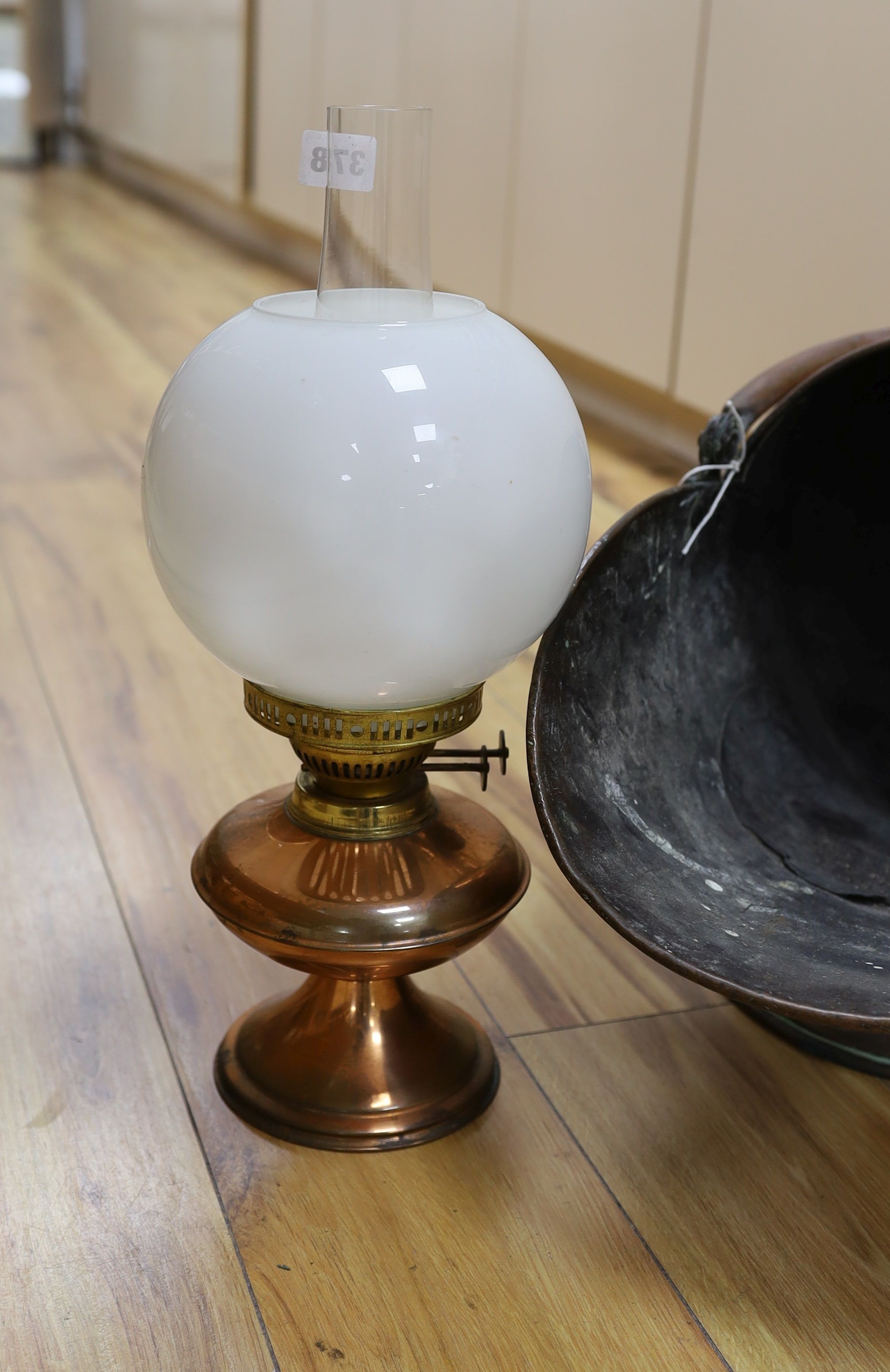 A Victorian copper coal scuttle and a lamp